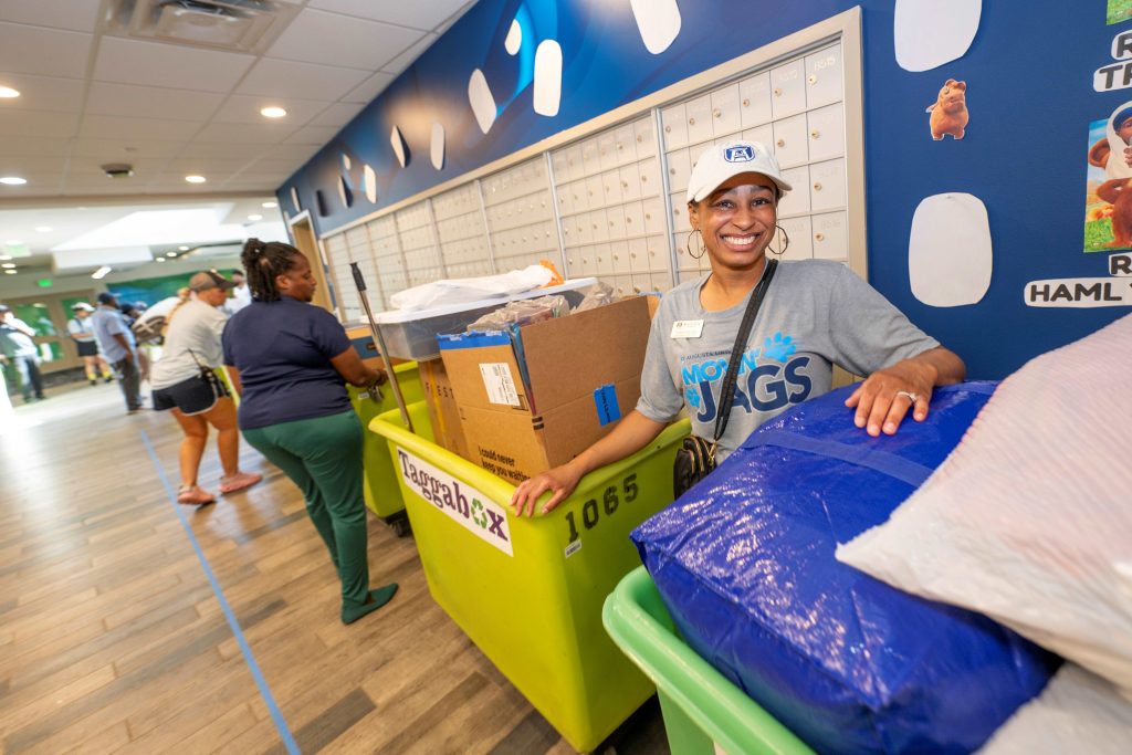 A woman stands between two move-in carts while waiting in a line.