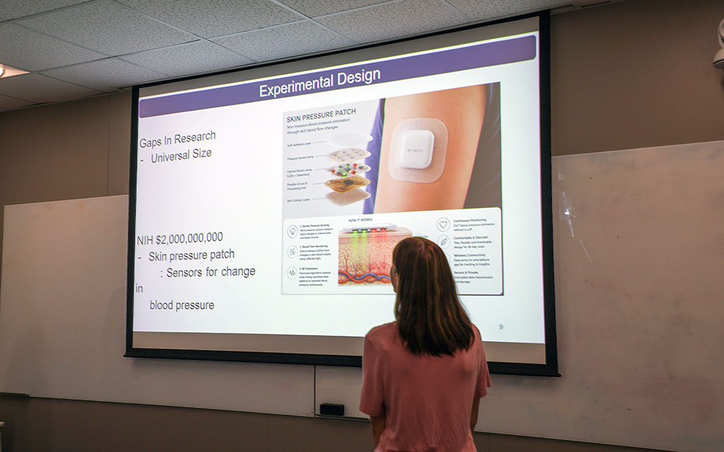 Woman standing in front of a screen that has a graphic on it.
