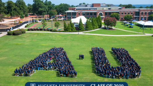 group of people gathered together in an A and U shape
