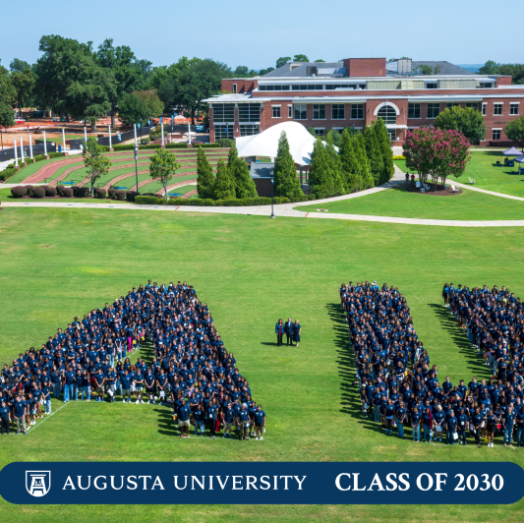 group of people gathered together in an A and U shape
