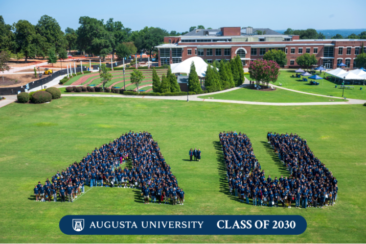 group of people gathered together in an A and U shape