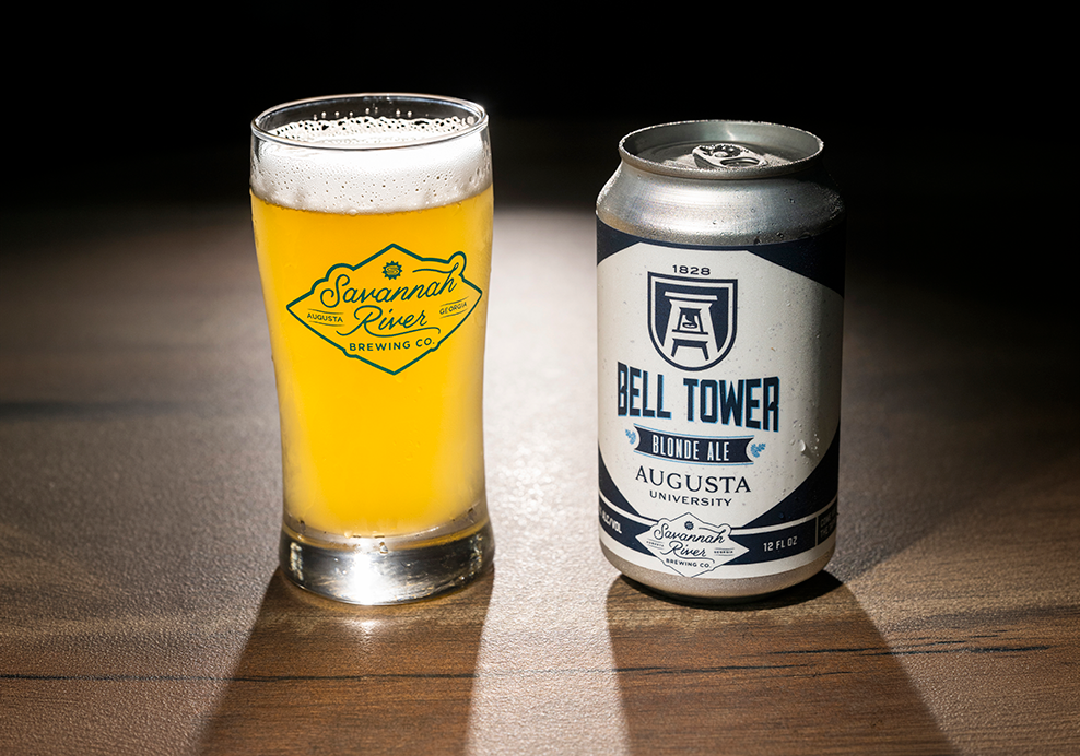 a glass of beer and a can of beer on a wooden surface