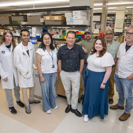 A group of people stand in front of lab equipment