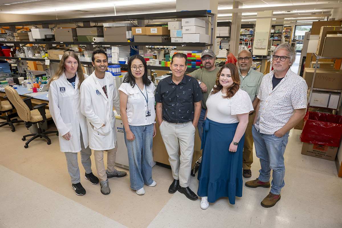 A group of people stand in front of lab equipment