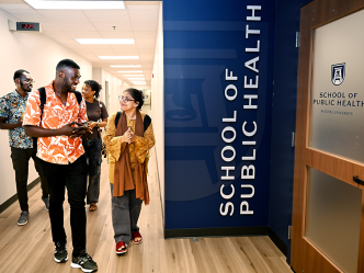 A group of four students walk down a hallway.