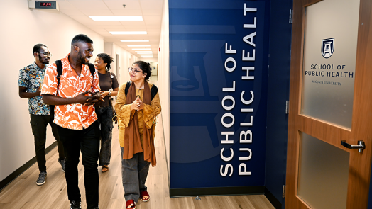 A group of four students walk down a hallway.