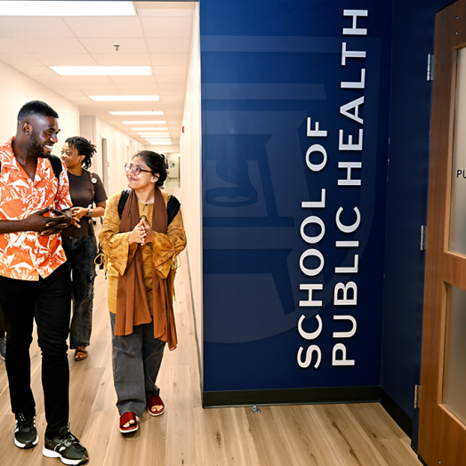 A group of four students walk down a hallway.