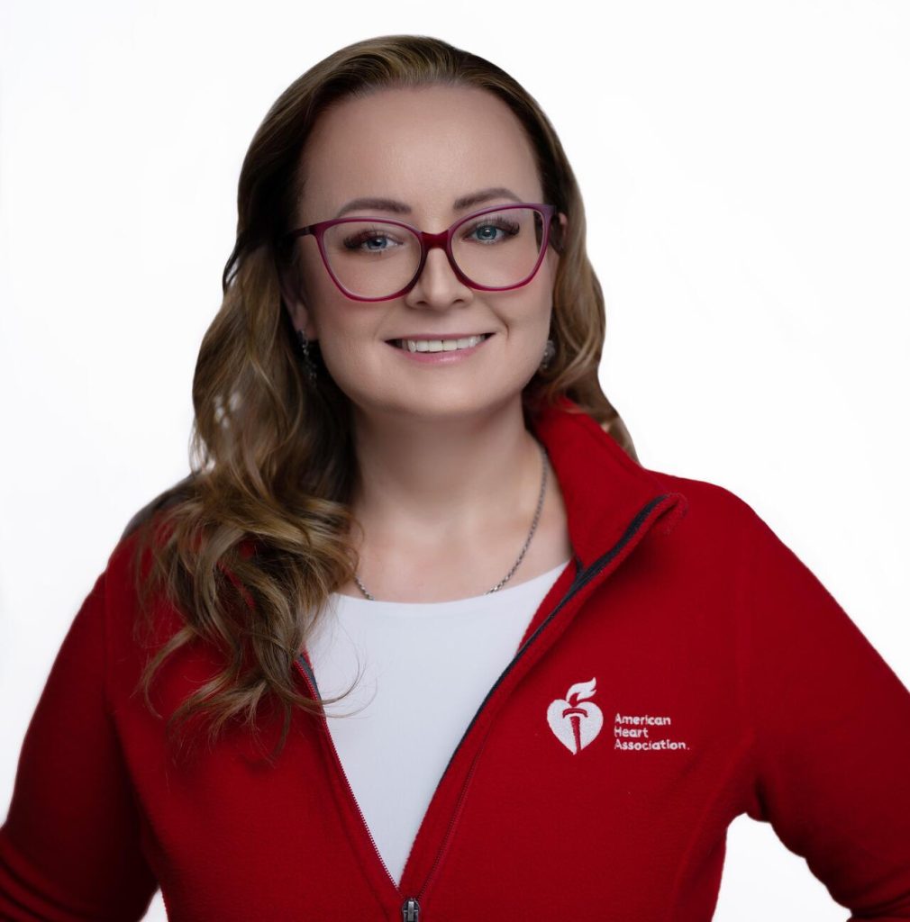 woman wearing glasses and a red jacket smiling