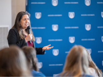 woman speaking and holding a microphone
