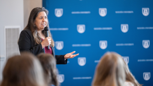 woman speaking and holding a microphone