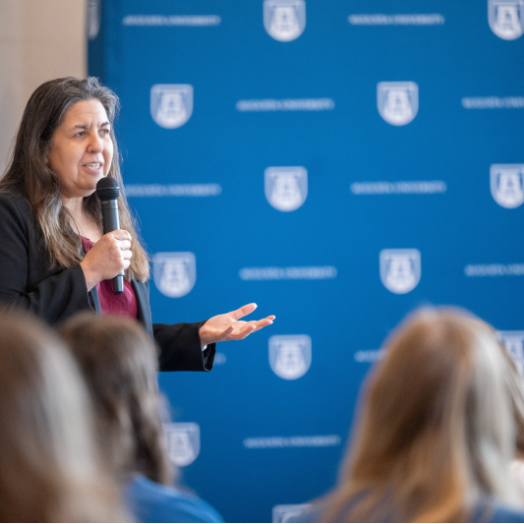 woman speaking and holding a microphone