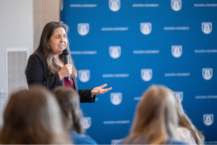woman speaking and holding a microphone