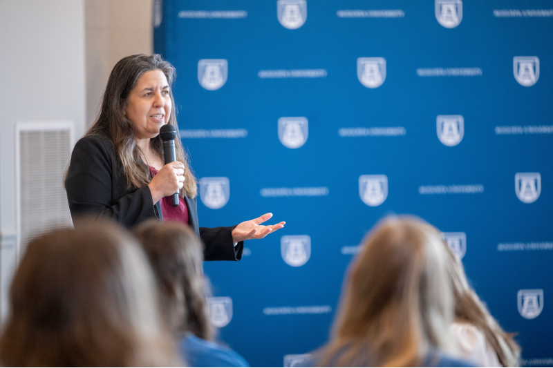 woman speaking and holding a microphone