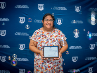 Female smiles as she holds her award