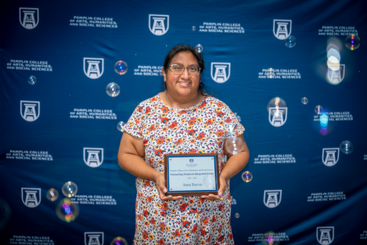 Female smiles as she holds her award