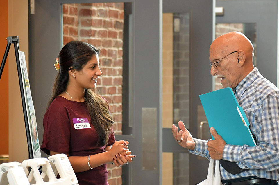 Man and young woman share discussion inside the HUB for Community Innovation.