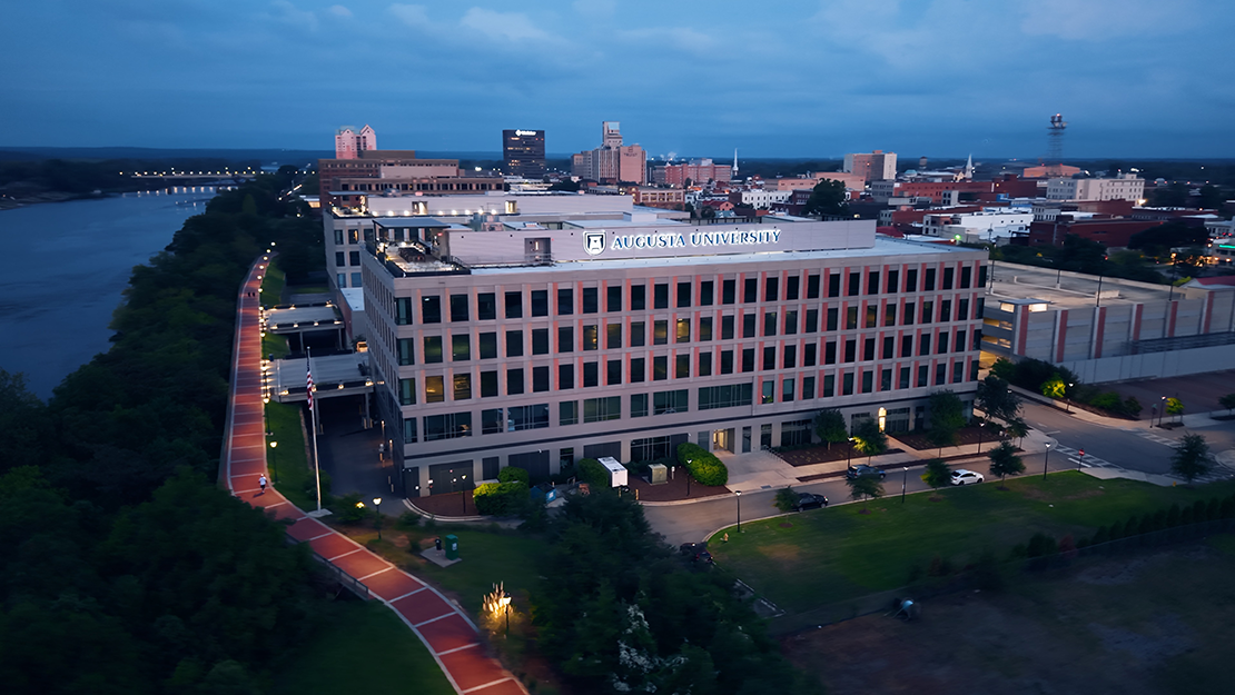 aerial of large building alongside river