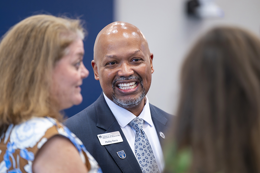 Man smiling while talking to people