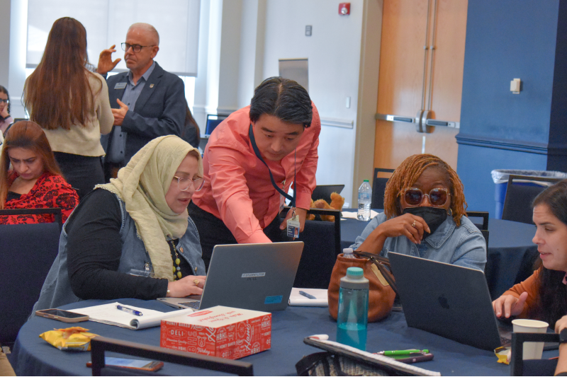 man pointing at a woman's computer screen.