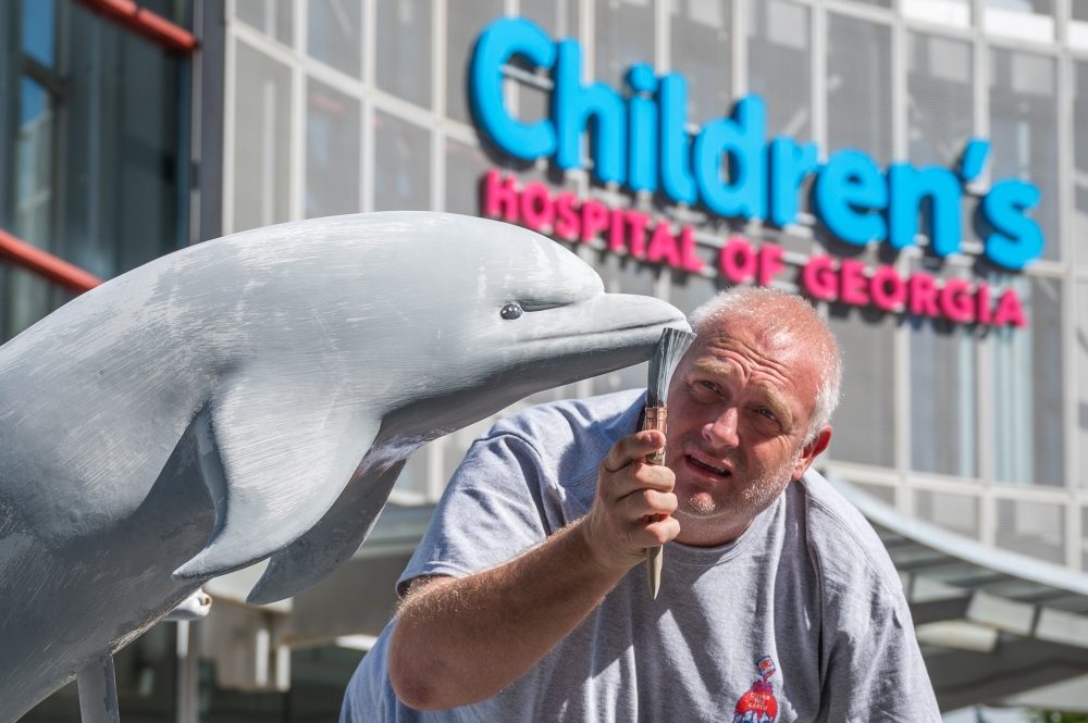 Jason Jenkins paints the one of the dolphins at the fountain outside the Children’s Hospital of Georgia.  Photographed May 11, 2021.

Photo by Michael Holahan/Augusta University

Job #
